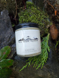 Jar of Sea Wolf Tailor Forest Fir moisturizer on a natural background with greenery